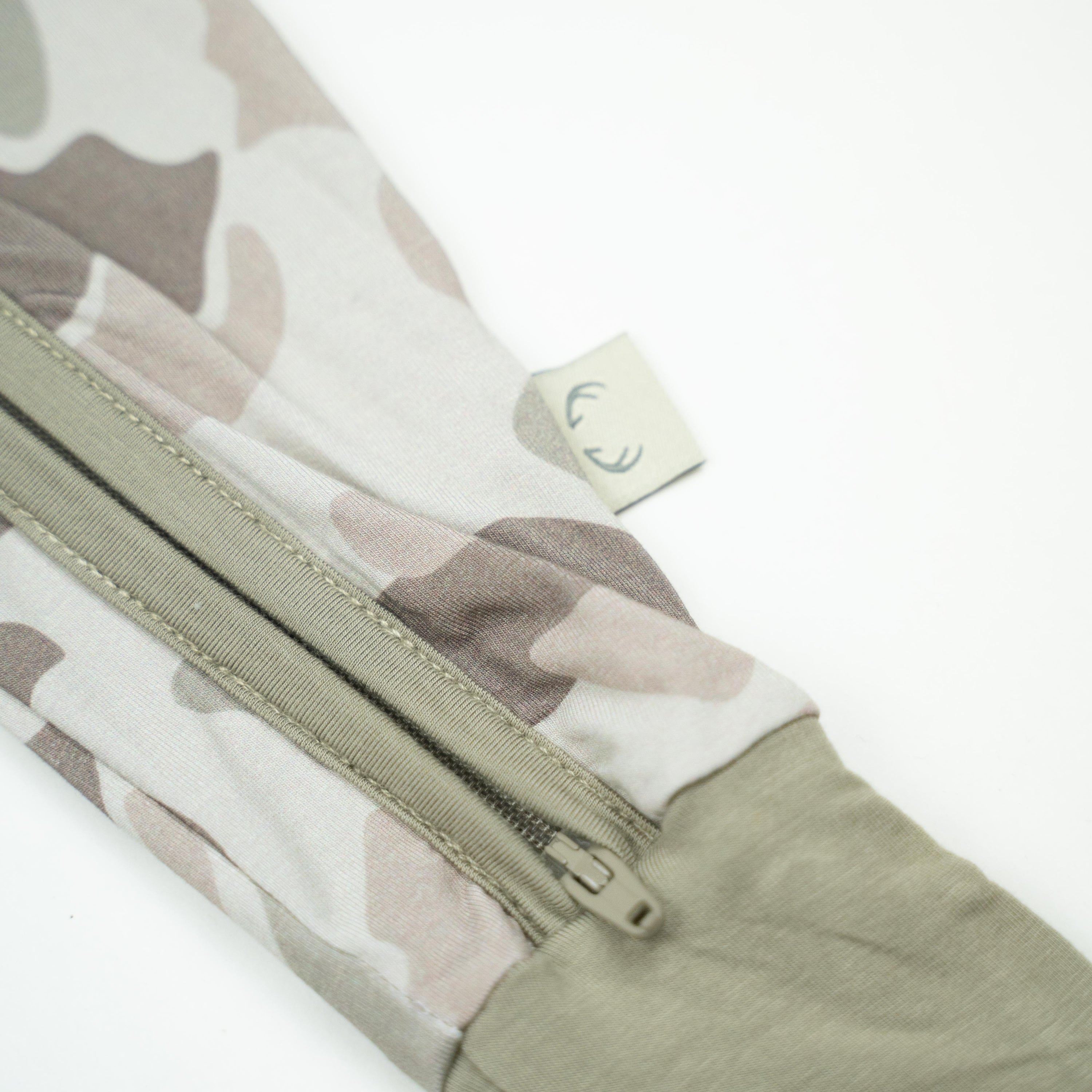 Close-up of Button Buck Camo Baby Zippy showcasing the camo pattern and double zipper detail.