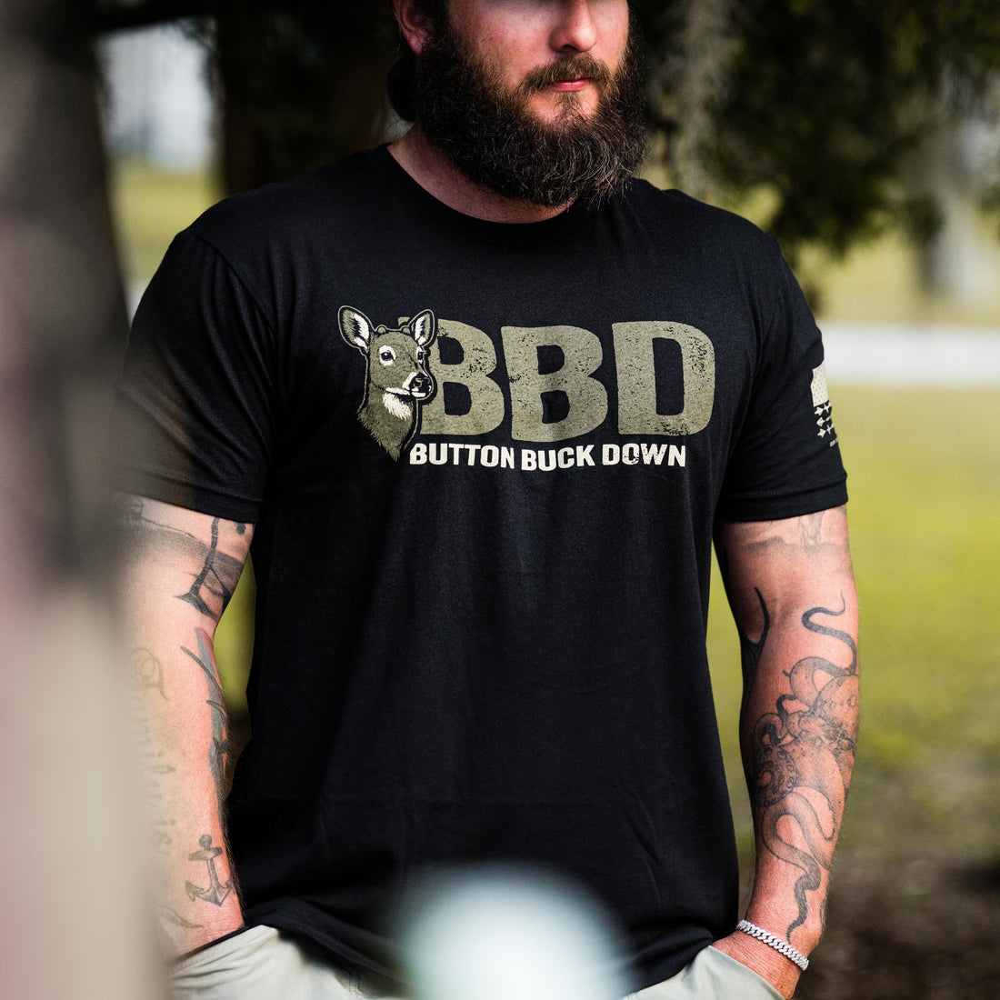 Man wearing BBD Tee - Premium Casual Graphic T-Shirt with deer graphic design outdoors.