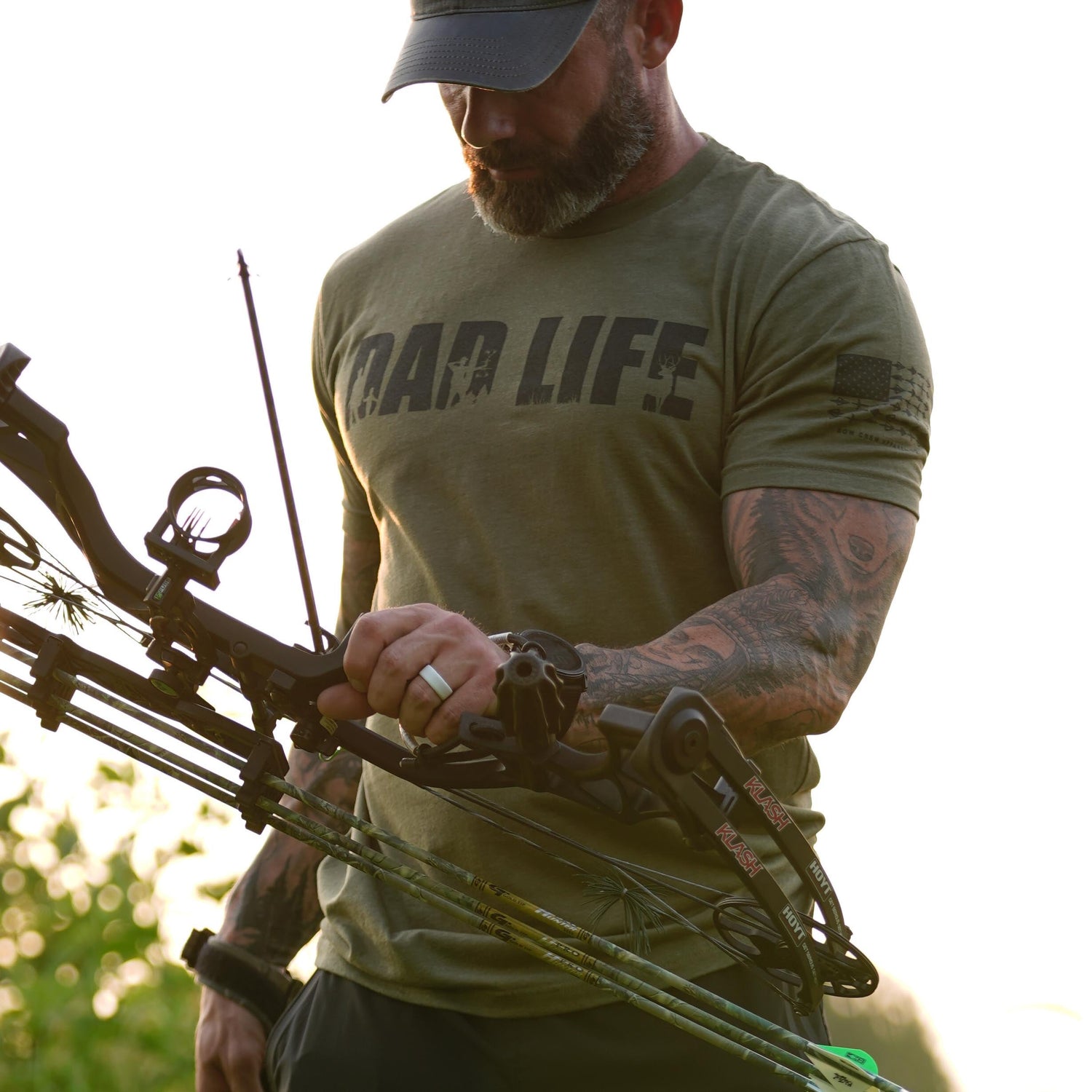 Dad Life T-Shirt worn by a man holding a bow, showcasing the comfortable graphic tee for hunting dads.